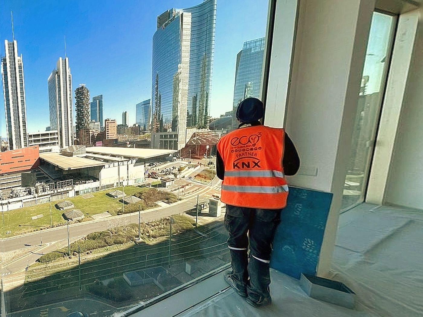 Tecnico ECO3 al lavoro in una torre direzionale con vista sullo skyline di Milano Porta Nuova