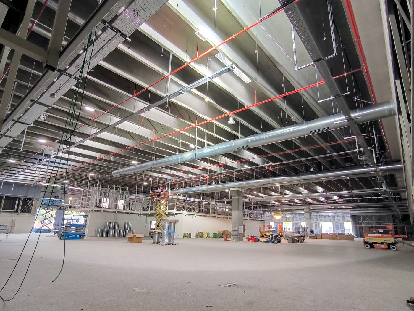 Interno di una grande superficie commerciale con canaline, dorsali e impianti a soffitto in fase di posa